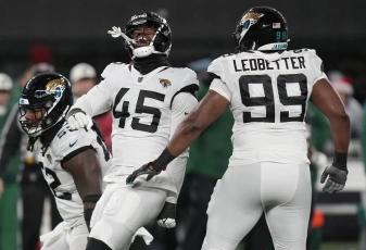 Jacksonville Jaguars linebacker K'Lavon Chaisson (45) celebrates with defensive tackle DaVon Hamilton (52) and defensive end Jeremiah Ledbetter (99) after a sack against the New York Jets on Thursday in East Rutherford, N.J. (SETH WENIG/Associated Press)