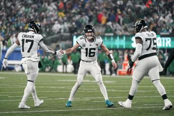 Jacksonville Jaguars quarterback Trevor Lawrence (16) celebrates with tight end Evan Engram (17) and offensive tackle Jawaan Taylor (75) after scoring a touchdown against the New York Jets on Thursday in East Rutherford, N.J. (SETH WENIG/Associated Press)