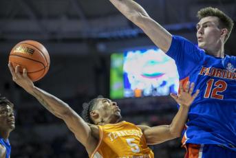 Tennessee guard Zakai Zeigler drives under pressure from Florida forward Colin Castleton during Wednesday's game in Gainesville. (ALAN YOUNGBLOOD/Associated Press)