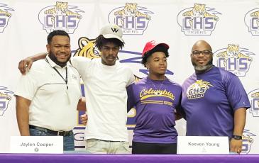 Columbia running back/receiver Jaylen Cooper (center left) and receiver Keeven Young (center right) signed letters of intent on Monday to play collegiately. Cooper is headed to Warner, while Young will play at Carthage. The duo are pictured alongside assistant coaches Anthony Newton (left) and Al Nelson (right). (COURTESY)