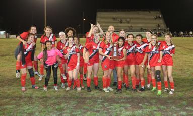 Lafayette’s girls soccer team celebrates with the District 2-2A trophy after defeating Bell 3-0 on Wednesday night. (PAUL BUCHANAN/Special to the Reporter)