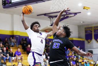 Columbia forward Ty’jahn Wright flies for a dunk as Ridgeview forward Jairus Moore contests during Wednesday’s District 2-5A semifinal. (BRENT KUYKENDALL/Lake City Reporter)