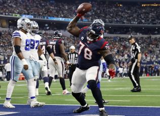 Houston Texans offensive tackle Laremy Tunsil (78) spikes the football after receiving it from running back Dameon Pierce (31) following a touchdown against the Dallas Cowboys at AT&T Stadium on Dec. 11, 2022, in Arlington, Texas. (TOM FOX/The Dallas Morning News/TNS)