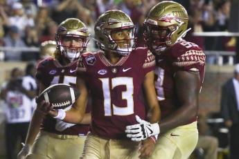 Florida State quarterback Jordan Travis (13) is congratulated by offensive lineman Maurice Smith (53) after scoring a touchdown against Florida on Nov. 25, 2022, in Tallahassee. (PHIL SEARS/Associated Press)