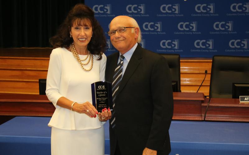 Rhonda Sherrod accepted the ‘Teacher of a Lifetime’ award for the late Michael Flanagan, her uncle, from school board member Keith Hudson. (TONY BRITT/Lake City Reporter)