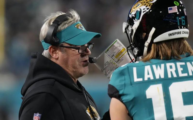 Jacksonville Jaguars head coach Doug Pederson (left) speaks to Jacksonville Jaguars quarterback Trevor Lawrence on the sidelines during last Saturday's wild-card playoff game against the Los Angeles Chargers in Jacksonville. (CHRIS O'MEARA/Associated Press)