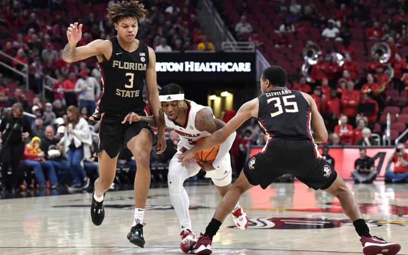 Florida State guard Matthew Cleveland (35) tries to strip the ball away from Louisville guard El Ellis (3) during Saturday’s game in Louisville, Ky. (TIMOTHY D. EASLEY/Associated Press)