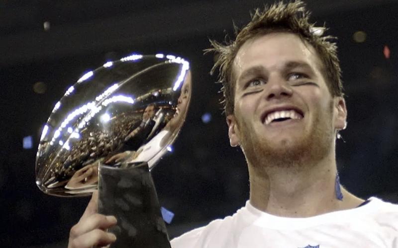 New England Patriots quarterback Tom Brady holds the Vince Lombardi Trophy after the Patriots beat the Carolina Panthers 32-29 in Super Bowl 38 on Feb. 1, 2004, in Houston. (AP FILE)