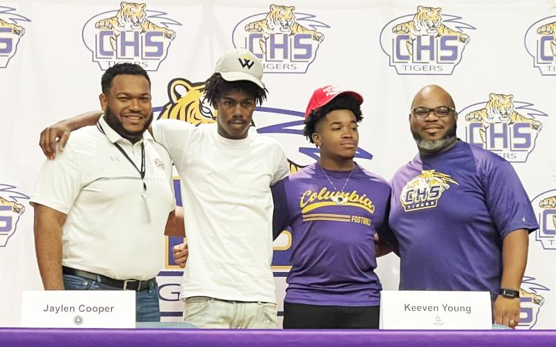 Columbia running back/receiver Jaylen Cooper (center left) and receiver Keeven Young (center right) signed letters of intent on Monday to play collegiately. Cooper is headed to Warner, while Young will play at Carthage. The duo are pictured alongside assistant coaches Anthony Newton (left) and Al Nelson (right). (COURTESY)