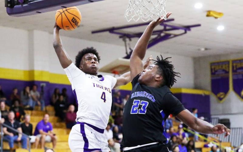 Columbia forward Ty’jahn Wright flies for a dunk as Ridgeview forward Jairus Moore contests during Wednesday’s District 2-5A semifinal. (BRENT KUYKENDALL/Lake City Reporter)