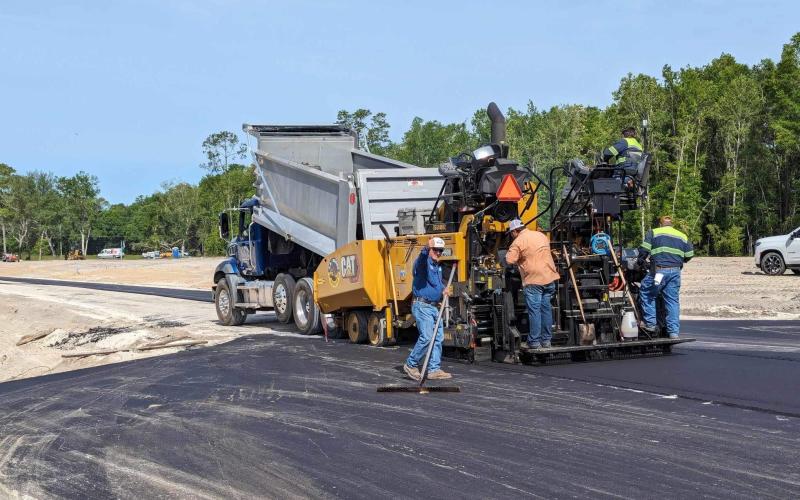 Paving crews from C.A. Boone Construction in Lake City apply smooth asphalt strips to a roadbed in the new Forest Cove subdivision on Wednesday. The new development on Branford Highway just south of Lake City features 14 one-acre lots in a rural setting and is being developed by local contractor Rob Stewart. (COURTESY)